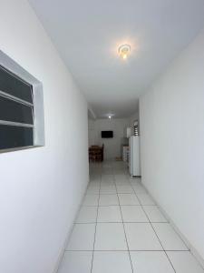 Una habitación vacía con un suelo de baldosas blancas y una ventana. en Chalé 2 novo mel, en Areia Branca 4 fotos más