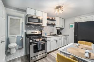 a kitchen with a stove and a microwave at The Downtown Delight - New Corporate Apt Downtown in Grand Rapids