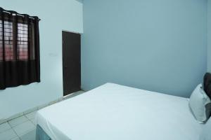 a room with a white bed with a blue light at Hotel O Shining Star in Bhilai
