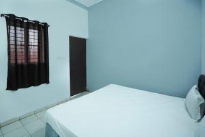 a room with a white bed with a blue light at Hotel O Shining Star in Bhilai