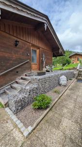 eine steinerne Mauer neben einem Gebäude in der Unterkunft Apartement für Naturliebhaber in Fischbachau