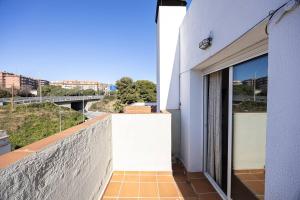 Un edificio con un balcón con vista a un puente. en House 5 Mins From Montgat Beach, en Montgat