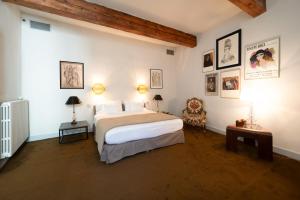 a bedroom with a large bed and a chair at la Maison Molière in Arles