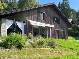 a house with a large window on the side of it at Golf und Berglodge Velden am Wörthersee in Köstenberg