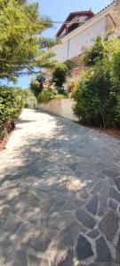 a stone road leading to a building with a tree at Anna Studio and Apartments in Tsilivi