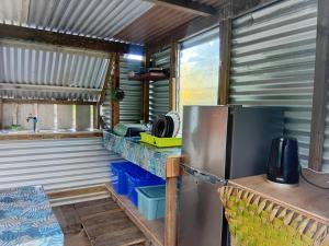 a kitchen with a stainless steel refrigerator and a counter at Chill Camp Tahaa in Patio