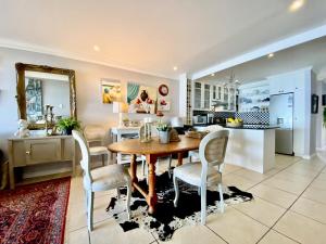 a kitchen and dining room with a wooden table and chairs at Oceanfront paradise - De Kelders in De Kelders