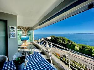 a balcony with a table and a view of the ocean at Oceanfront paradise - De Kelders in De Kelders