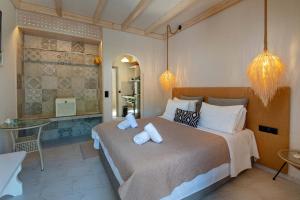 a bedroom with a large bed with two pillows at Arokaria Studios by PaxosRetreats in Gaios