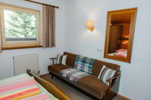 a living room with a couch and a mirror at Almblick Appartements in Sankt Jakob in Defereggen