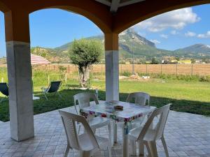 una mesa y sillas en un patio con montañas al fondo en EDEN - Paestum holiday home, en Paestum