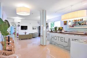 a hotel lobby with a reception counter and a living room at Hotel Itta in Caorle