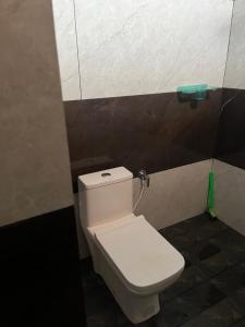 a bathroom with a white toilet in a stall at Akazumba home stay in Auroville