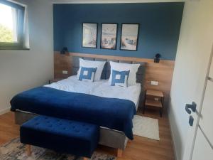 a bedroom with a large bed with blue sheets and pillows at Na Skraju - Pogorzelica - Domki Rekreacyjne lokal D in Pogorzelica