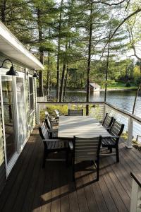 a wooden deck with a table and chairs on it at Tri-Lake Escape in Naples +41 photos