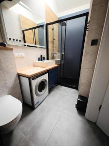 a bathroom with a washing machine and a sink at Na Skraju - Pogorzelica - Domki Rekreacyjne lokal D in Pogorzelica