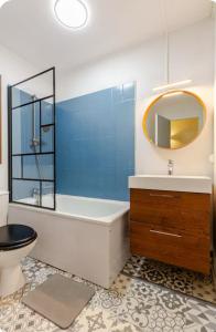 bagno con vasca, servizi igienici e specchio di Studios au pied des pistes , La Mongie Tourmalet, balcon plein Sud a La Mongie