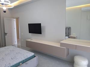 a white room with a tv on a wall at Sea Breeze in Nardaran
