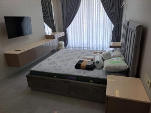 a bedroom with a bed with a tv and a window at Sea Breeze in Nardaran +8 photos