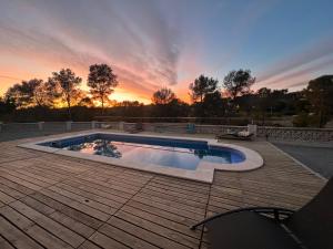a pool on a deck with a sunset in the background at Villallop in Olivella