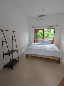 a bedroom with a bed and a window at ADA Rooms in Kuta Lombok
