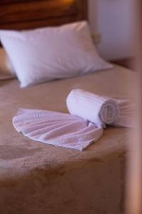 a towel on a bed with a clock on it at Casa Ivano com piscina, no melhor bairro in Porto Seguro +9 photos