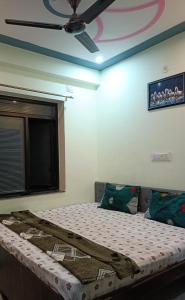 a bedroom with a bed with a ceiling fan at Hotel vijay in Palāi