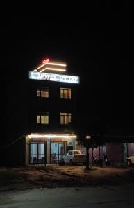a hotel sign on top of a building at night at Hotel vijay in Palāi +7 photos