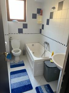 a bathroom with a tub and a toilet and a sink at Apartament Mamaia-Nord 5min de mers pe plaja in Mamaia Nord
