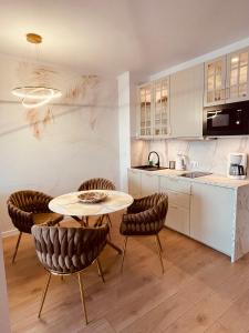 a kitchen with a table and chairs in a room at Sunrise Euronia in Międzyzdroje