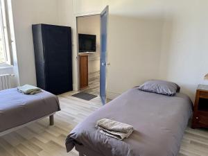 a bedroom with two beds and a television in it at F 36 Raimbaux 2 à 4 Personne 2 chambres Wifi Parking facile in Imphy