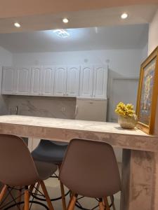a kitchen with a counter with two chairs and a table at Apartman LENA in Trebinje +17 photos