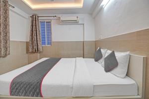 a bedroom with a bed with white sheets and pillows at Townhouse Empire Executive in Pune +47 photos