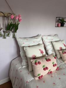 a bed with four pillows with flowers on it at LODGE Site escalade in Saint-Pierre-lès-Nemours