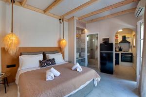 a bedroom with a large bed with towels on it at Arokaria Studios by PaxosRetreats in Gaios