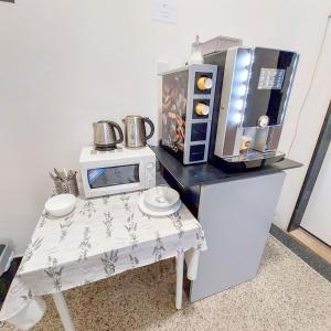 a small kitchen with a table with a microwave at Nový pokoj u Pražského výstaviště A3 in Prague