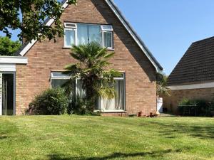 a house with a palm tree in front of it at Zen suite in Oadby