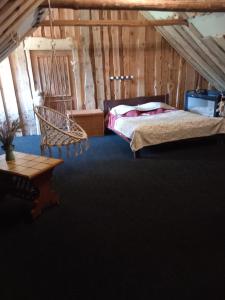 a bedroom with a bed and a chair and a table at Brīvdienu māja- Silavas in Rucava