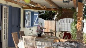 a patio with a table and chairs and a blue door at Fleurs de mangue in Saint-Louis