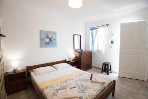una camera da letto con un letto, un comò e uno specchio di PAROS APARTMENT MELAS b2 a Paroikia Altre 16 foto