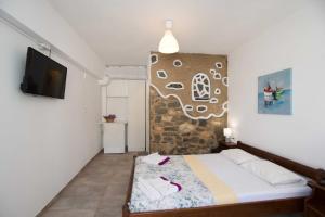 una camera con letto e parete con TV di PAROS APARTMENT MELAS b2 a Paroikia