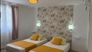 a bedroom with two beds with yellow and white pillows at Fleurs de mangue in Saint-Louis +5 photos