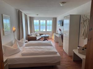 a hotel room with two beds and a living room at Apartment-Hotel Perle am Bodden in Ribnitz-Damgarten