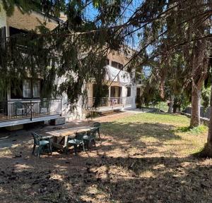 a picnic table and chairs in front of a building at Appartamento nel verde a Gravere in Gravere