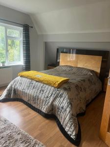 a bed with a comforter and a yellow pillow on it at Zen suite in Oadby