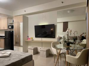 a living room with a table and a kitchen at Shore Luxe in Sampong