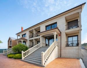 a building with a staircase in front of it at Apartamentos Casa Ameirós in O Grove