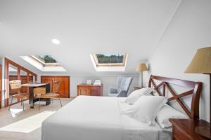a bedroom with a bed and a table and chairs at Apartamentos Casa Ameirós in O Grove +35 photos