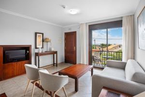 a living room with a couch and a tv at Apartamentos Casa Ameirós in O Grove