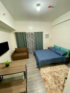 ダバオシティにあるAmani Grand Citygateのベッドルーム(青いベッド1台、ソファ付)